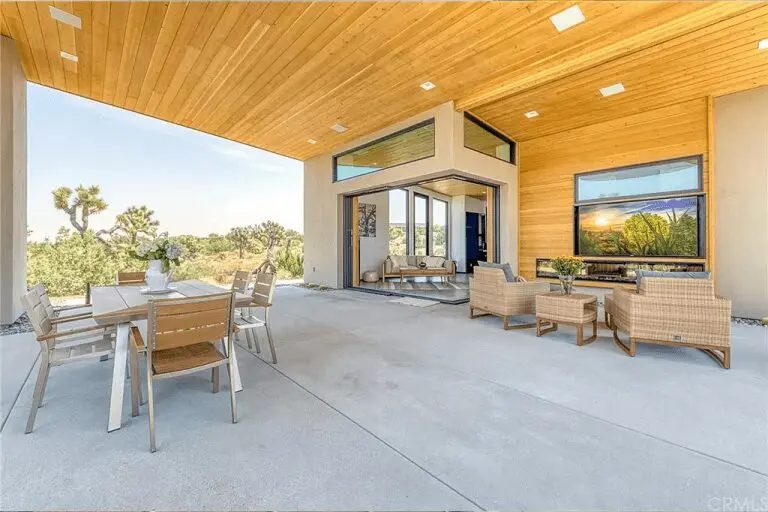 A patio with chairs and tables outside of the house.