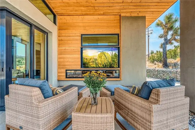 A patio with wicker furniture and a television.