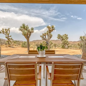 A table and chairs in front of an open window.