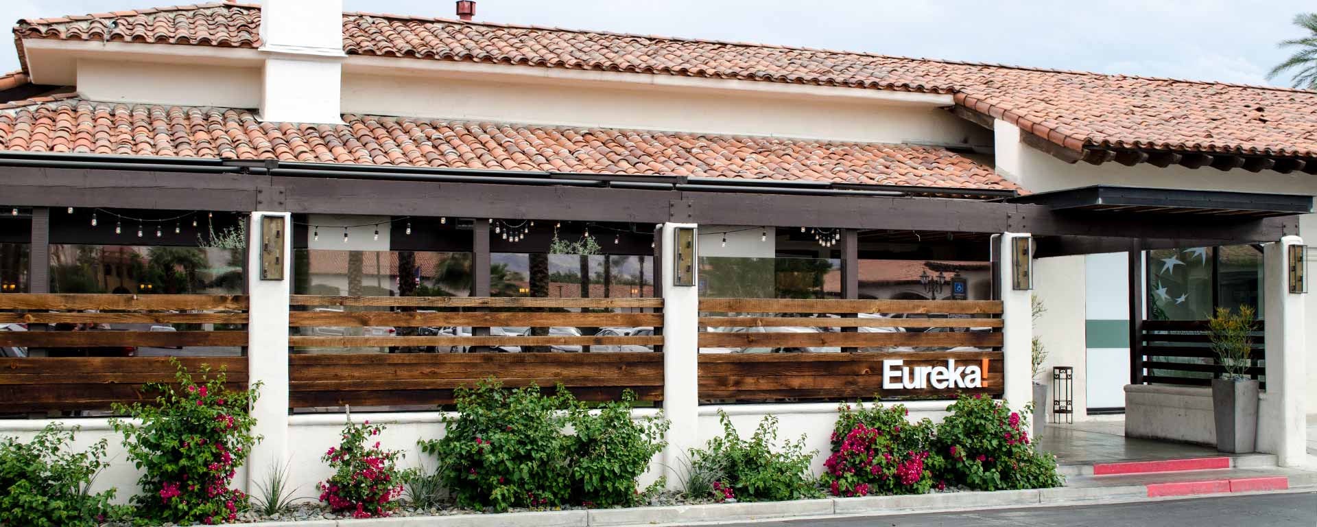 A restaurant with a large wooden awning on the side of it.