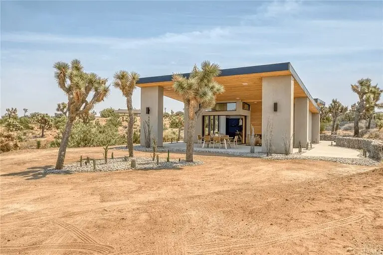 A desert house with palm trees in the background.